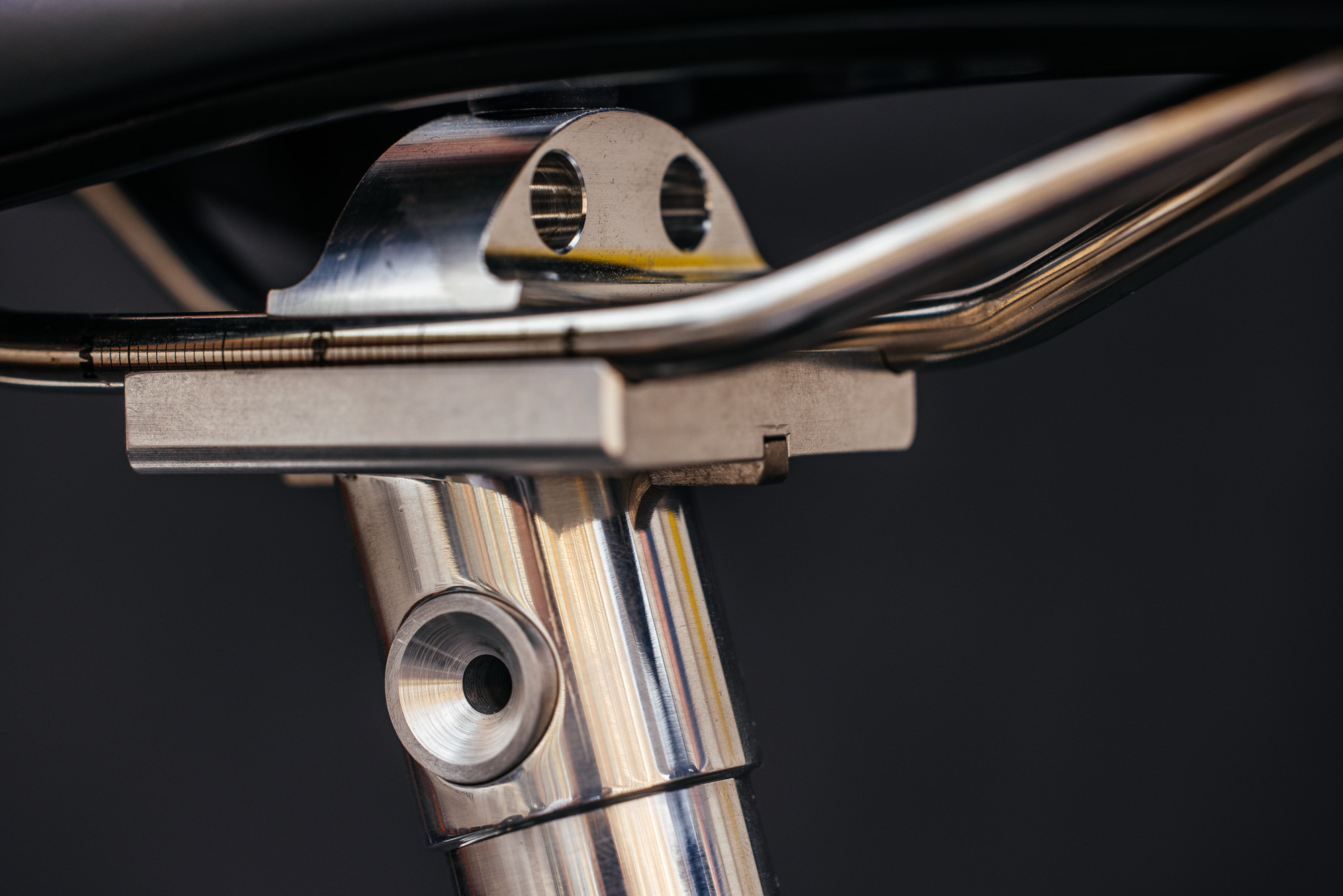 Polished titanium frame detail and cable guide on a handmade bicycle